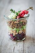 A lentil salad with roast beef and beetroot in a glass jar
