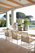 Outdoor furniture on roofed terrace with view of pool