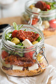 Couscoussalat mit getrockneten Tomaten, Feta und Oliven im Bügelglas