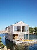 Two-storey wooden house with terrace floating on lake