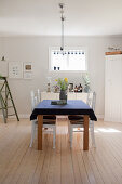 Bright dining room in simple country-house style with wooden floor