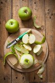 Green Bramley apples, whole and peeled, with an apple peeler