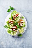 Lettuce boat filled with chicken breast, cucumber, avocado, feta and herbs