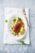 Spicy chicken breast on couscous with shallots and mint (top view)