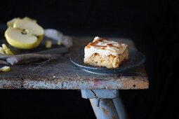 A piece of apple cake on a rustic stool