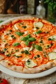 Vegetarian pizza with tomatoes, zucchini and pesto