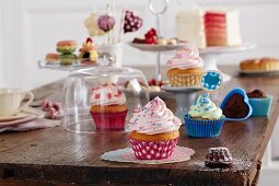 Different cupcakes, small pastries and cakes on a wooden table