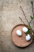 An arrangement of eggs and twigs on a clay plate for Easter
