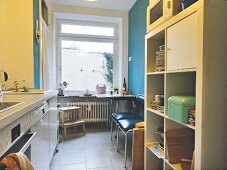 A unit and open shelf in a kitchen with a table and chairs in the background