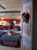 View into cosy chalet bedroom with teddy bears, lamps and Christmas presents