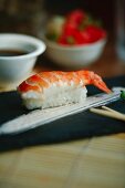 Nigiri sushi with shrimp on a black plate