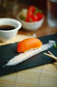 Nigiri sushi with salmon on a black plate