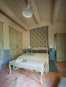 Upholstered bench at foot of bed in Mediterranean bedroom