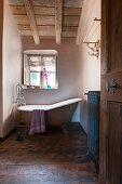 Freistehende Badewanne unter dem Fenster im nostalgischen Bad