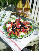 A summer salad with grilled duck breast wrapped in bacon
