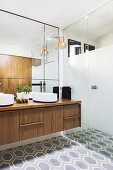 Elegant bathroom with walk-in shower, double walnut vanity, wall mirror and hexagonal floor tiles