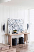 Modern art and vases on wooden console table in the hallway