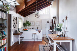 Table with two chairs, kitchen counter with bar stool in background