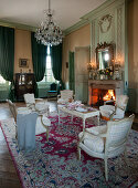 Upholstered chairs and table set for afternoon coffee in historical parlour