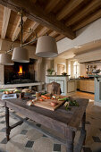 Rustic wooden table in traditional kitchen with open fireplace