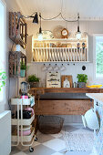 Plate rack above old workbench in country-house kitchen