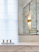 Glamorous modern bathroom with marble, gilt and mirrored elements