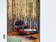 Classic Eames Lounge Chair with black leather upholstery and matching footstool in front of curtain