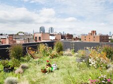 Begrüntes Dach mit Blumen und Stühlen und Blick auf Brooklyn und Manhattan