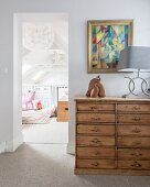 Wooden chest of drawers on landing outside room with gallery balustrade