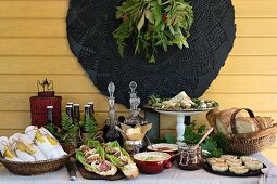 A summer buffet with mediterranean starters and dips, and a basket with rolled napkins