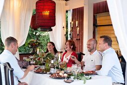 A garden party on a pavilion lit with red lanterns