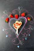 Waffles with sticks and strawberries on a decorated blackboard