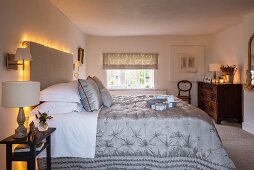 Bed headboard decorated with fairy lights in rustic bedroom