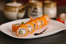 Salmon sushi with fresh cheese on a serving platter