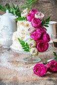 A rose water layer cake with meringue and pink roses