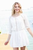 Blonde Frau in weißem Sommerkleid mit Lochmuster