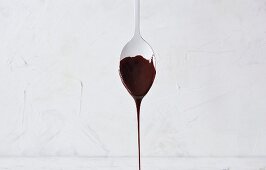 Melted chocolate dripping from a tablespoon
