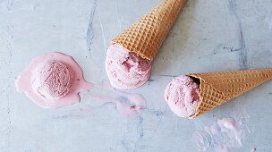 Cones with melting strawberry ice cream