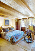 Rustic bedroom with wood-beamed ceiling and lattice windows
