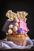 A cupcake decorated with biscuits and sweets
