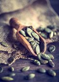 An arrangement of pumpkin seeds on a wooden scoop