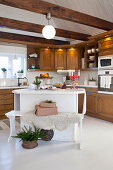 Bench next to island in country-house kitchen