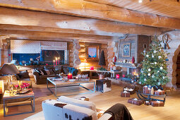 Wohnzimmer mit Weihnachtsbaum und Kerzendeko im Blockhaus