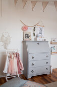 Old grey bureau and clothes rack in child's bedroom