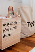 Wooden toy chest with motto made from stickers
