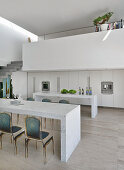 Marble table in front of minimalist kitchen below gallery