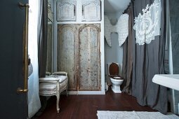 Toilet, decorated walls and curtain in vintage-style bathroom