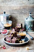 Chocolate fudge with pistachios, sprinkled with cherries, and served with coffee