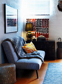 Day bed with plaid and pillows, and old Chinese cupboard with table lamp in the anteroom