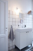 Washstand unit with countertop sink in white bathroom